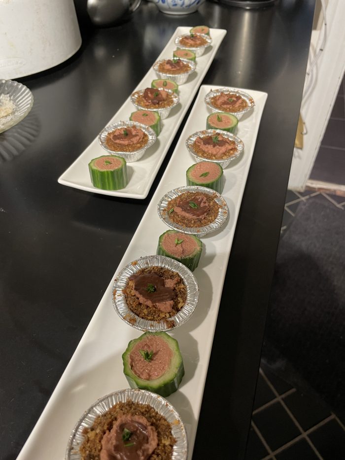 Rows of tiny tartlets on long white porcelain trays, ready to be giving to guests as finger food