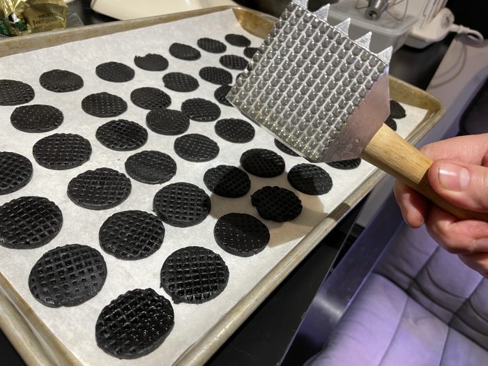 little round black cookies and a big meat mallet